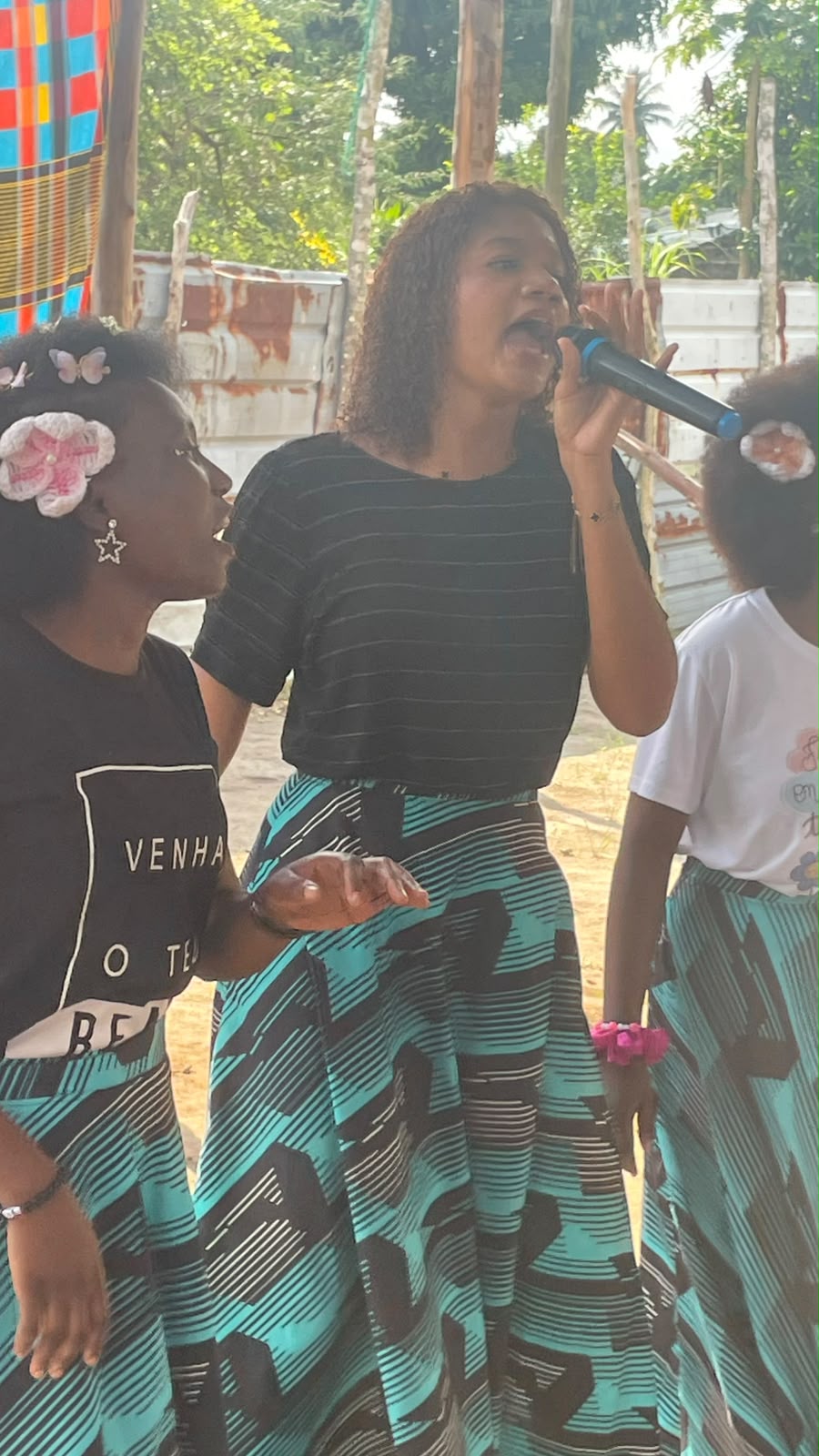 Jovem cantando ao microfone durante o louvor