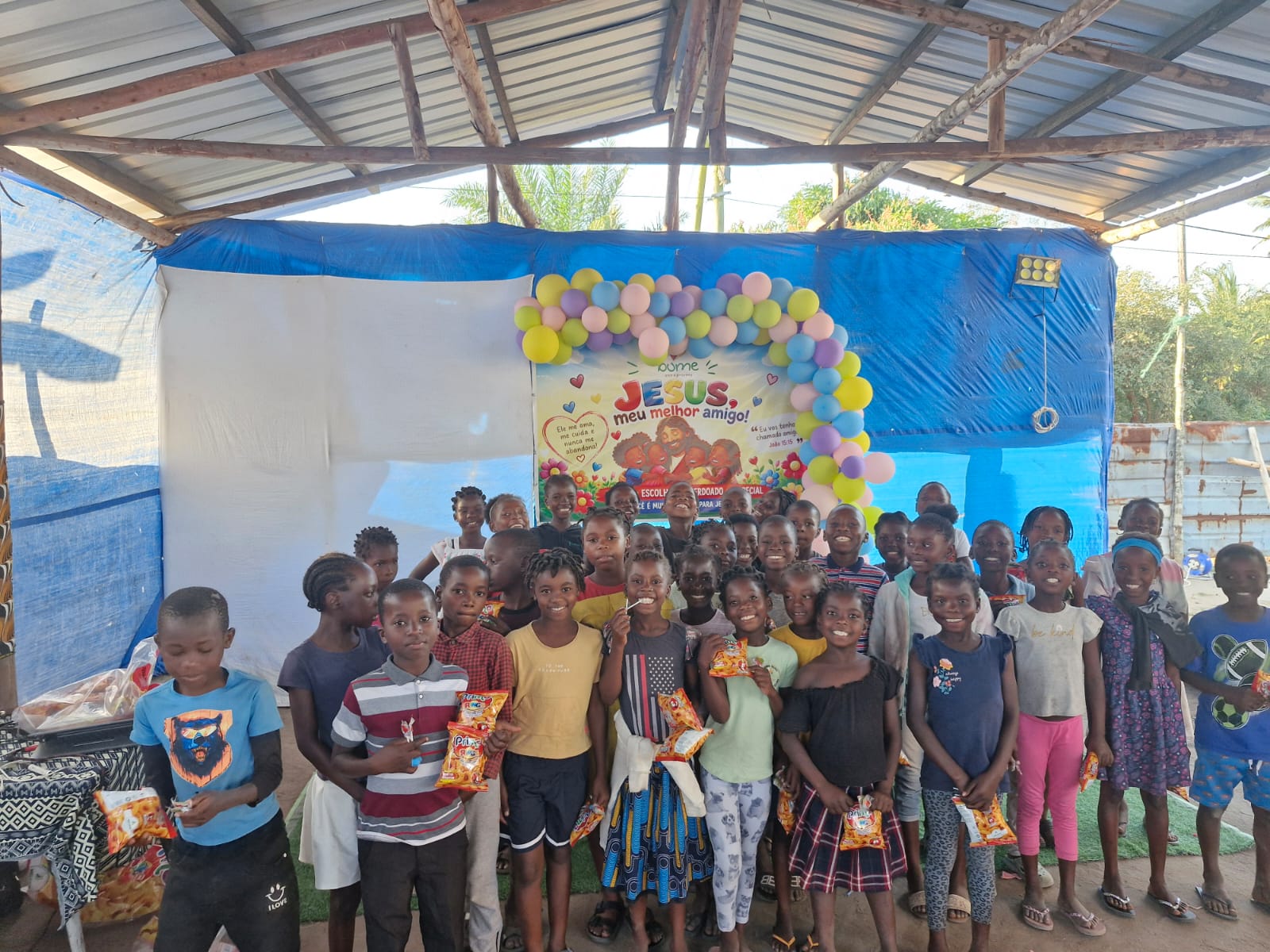 Crianças da EBF em Matongolo diante do painel Jesus, meu melhor amigo